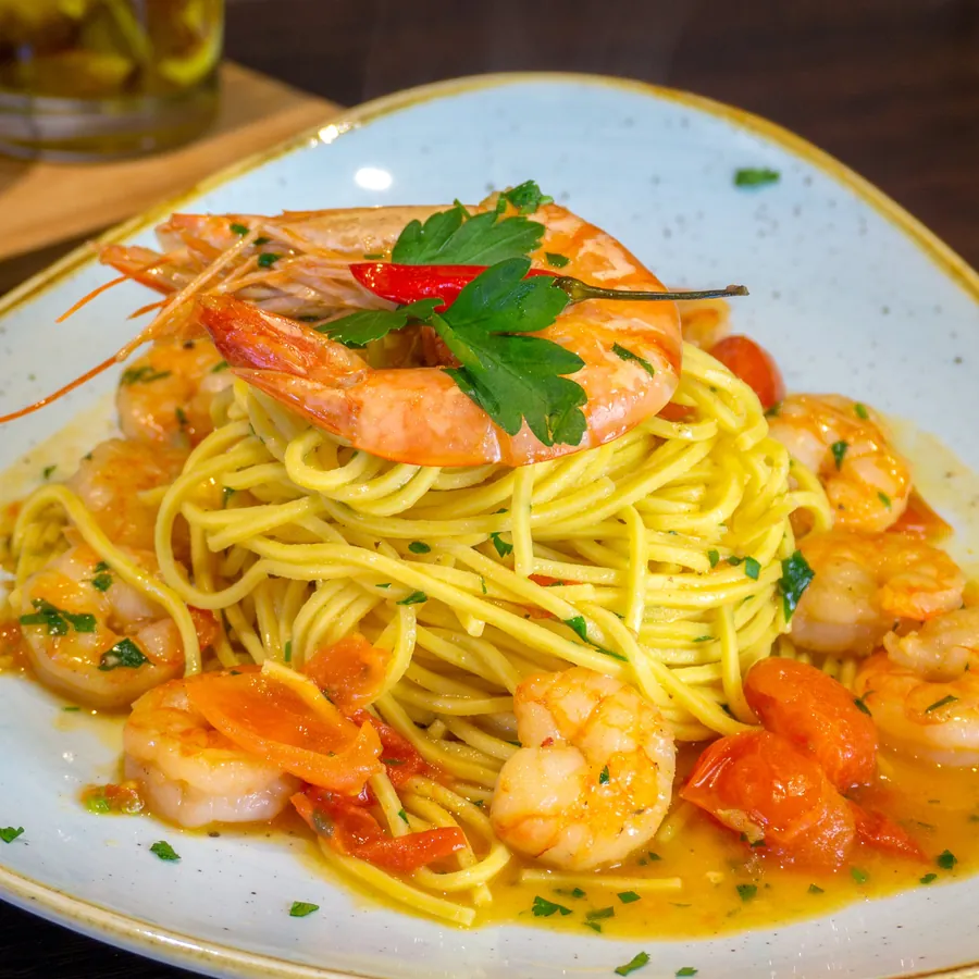 Spaghetti mit Scampi, Kirschtomaten und Petersilie.